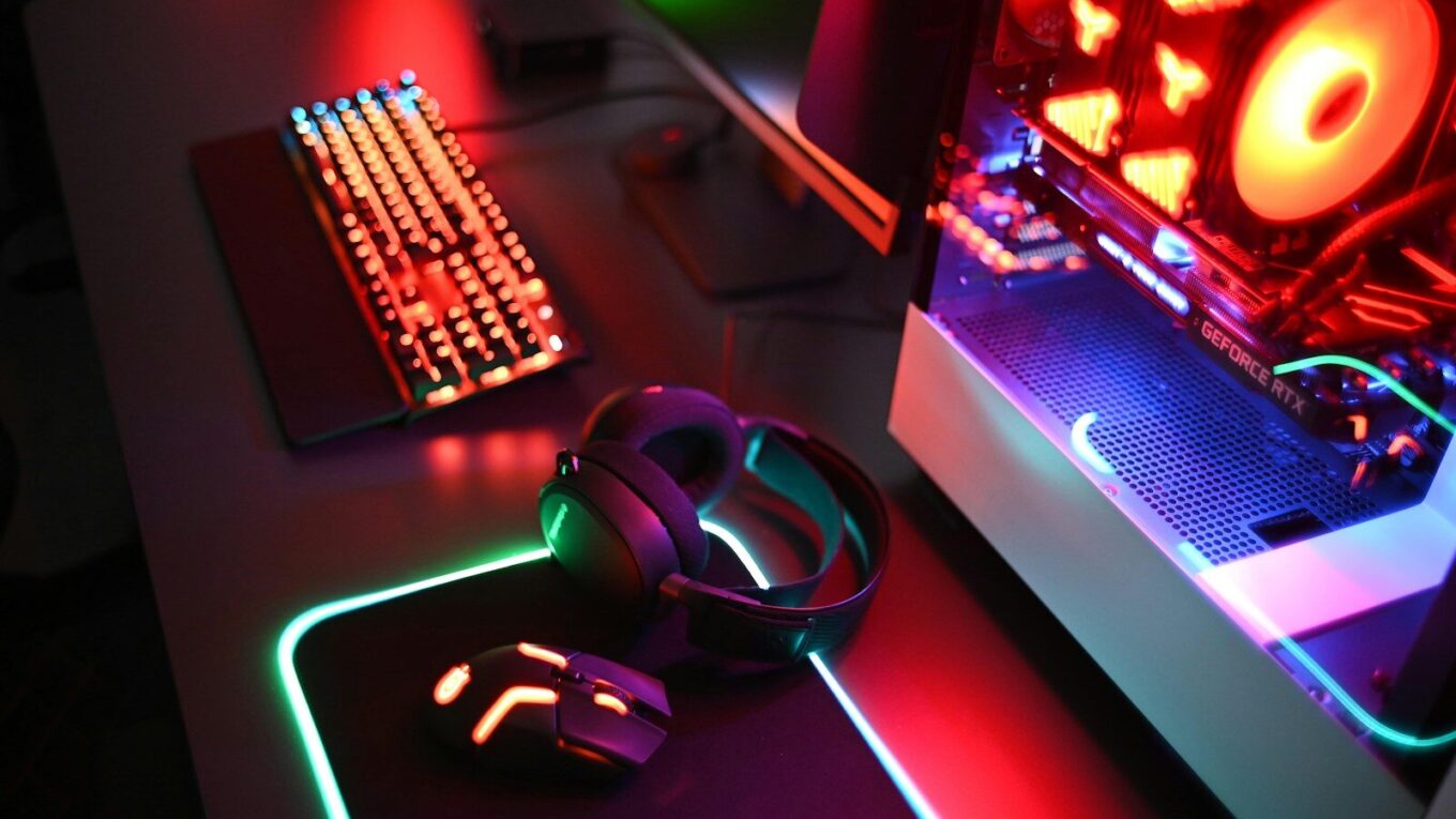 a computer with a keyboard, mouse and headphones
