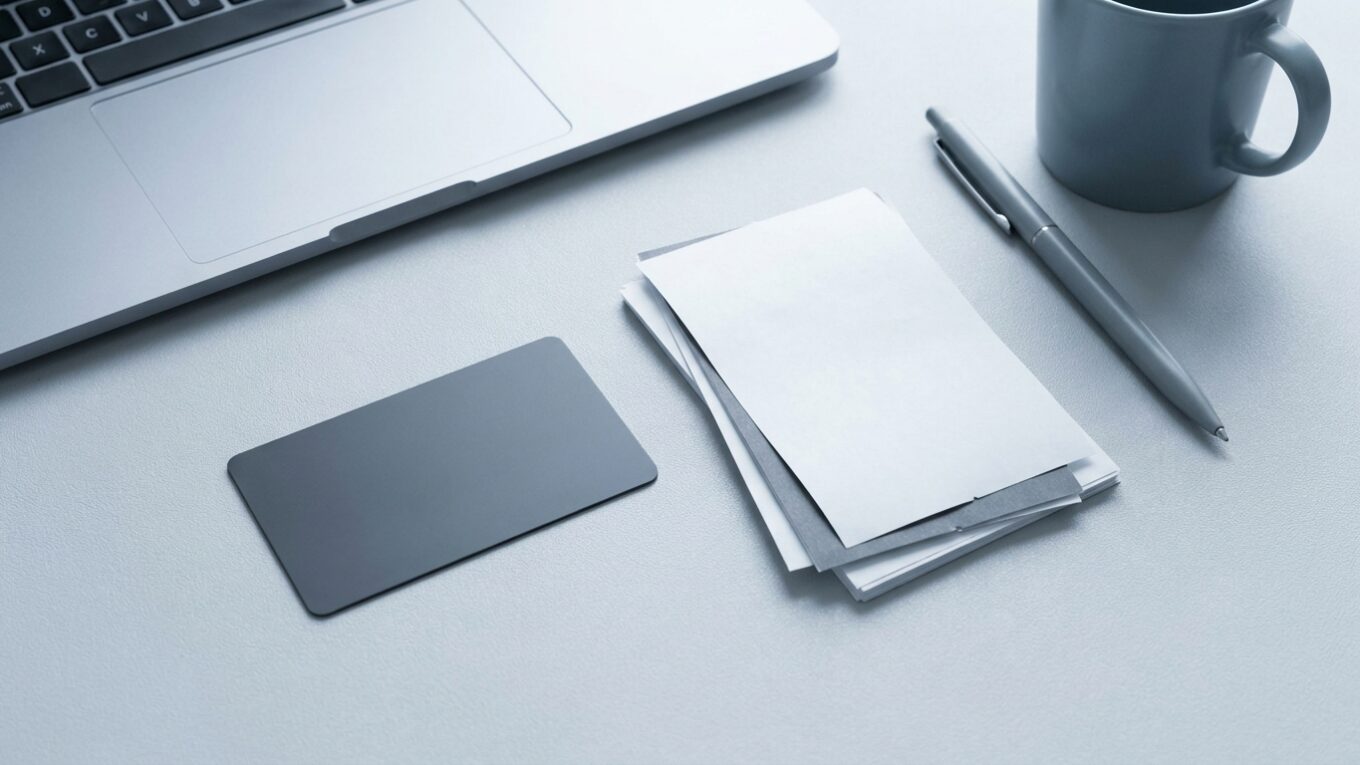 Firmenkreditkarte neben Belegen und Laptop auf einem Schreibtisch